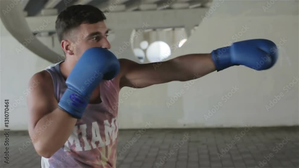 Boxer is on a training outdoors on the background of gray concrete walls with circular holes. Boxer is on a training outdoors on the background of gray concrete walls with circular holes.
