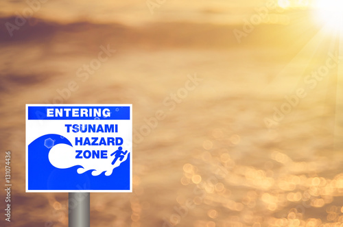 Warning zone tsunami sign on blur tropical sunset beach copy space abstract backgroud.