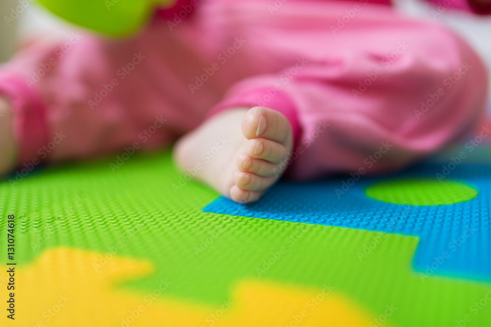 Close up of baby bare feet sitting on colorful puzzle play mat. Close up of baby bare feet sitting on colorful puzzle play mat.