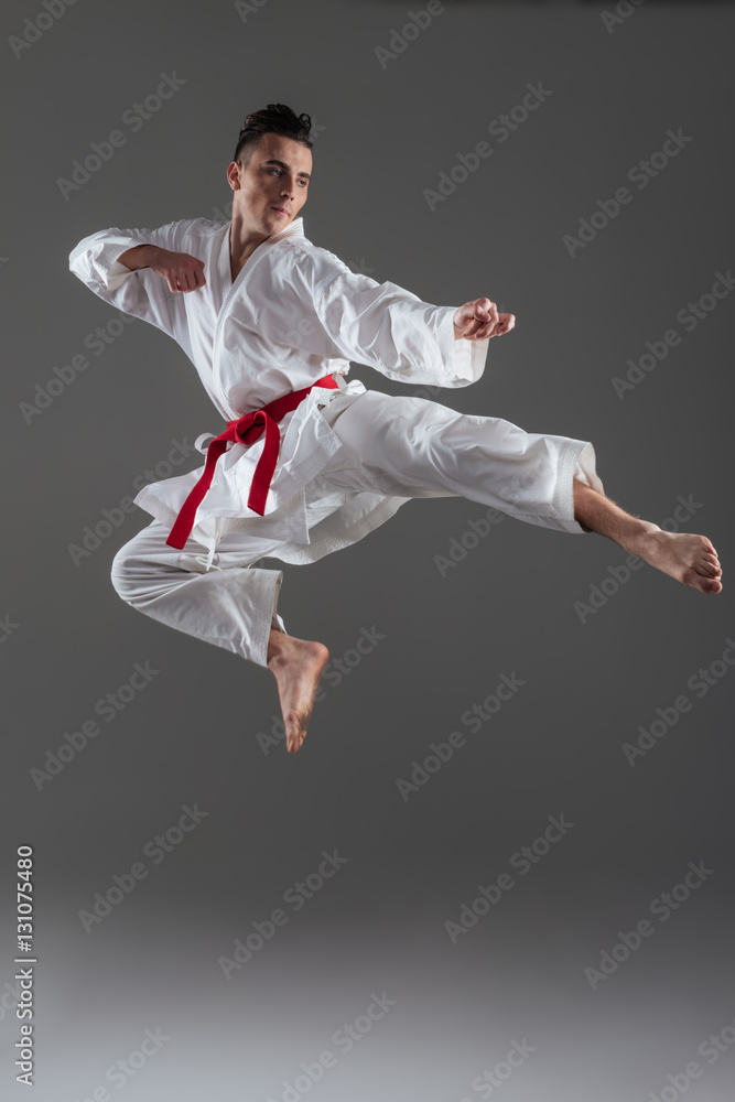 Attractive young sportsman dressed in kimono practice in karate