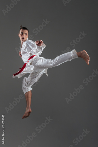 Handsome young sportsman dressed in kimono practice in karate