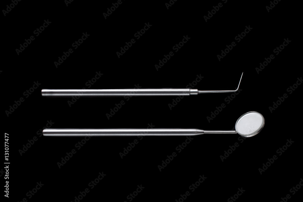 Dental mirror and dental sonde. Image isolated on black background Dental mirror and dental sonde. Image isolated on black background