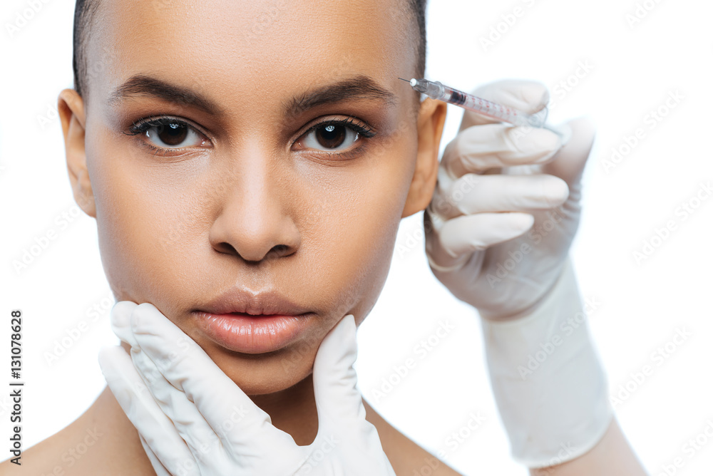 Motionless Negroid woman getting injection in her face Motionless Negroid woman getting injection in her face