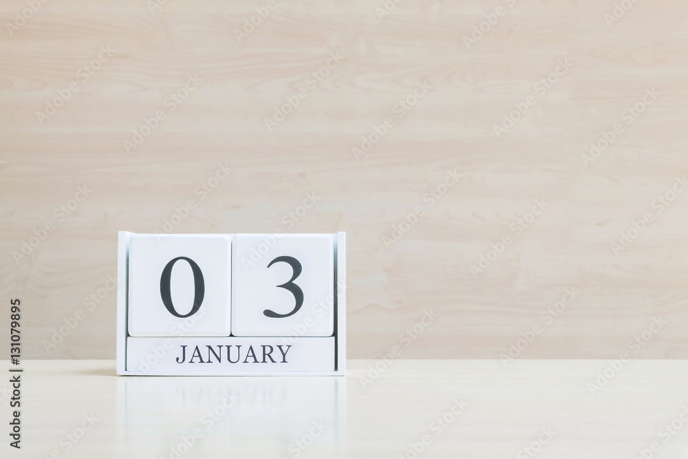 Closeup surface white wooden calendar with black 3 january word on blurred brown wood desk and wood wall textured background with copy space , selective focus at the calendar Closeup surface white wooden calendar with black 3 january word on blurred brown wood desk and wood wall textured background with copy space , selective focus at the calendar