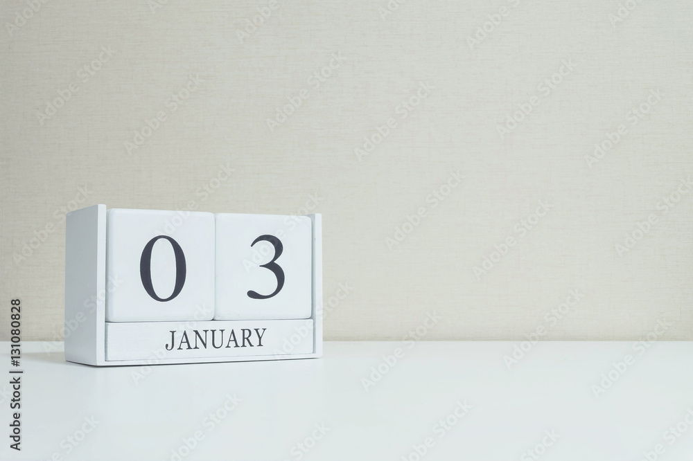 Closeup white wooden calendar with black 3 january word on blurred white wood desk and cream color wallpaper in room textured background with copy space , selective focus at the calendar Closeup white wooden calendar with black 3 january word on blurred white wood desk and cream color wallpaper in room textured background with copy space , selective focus at the calendar