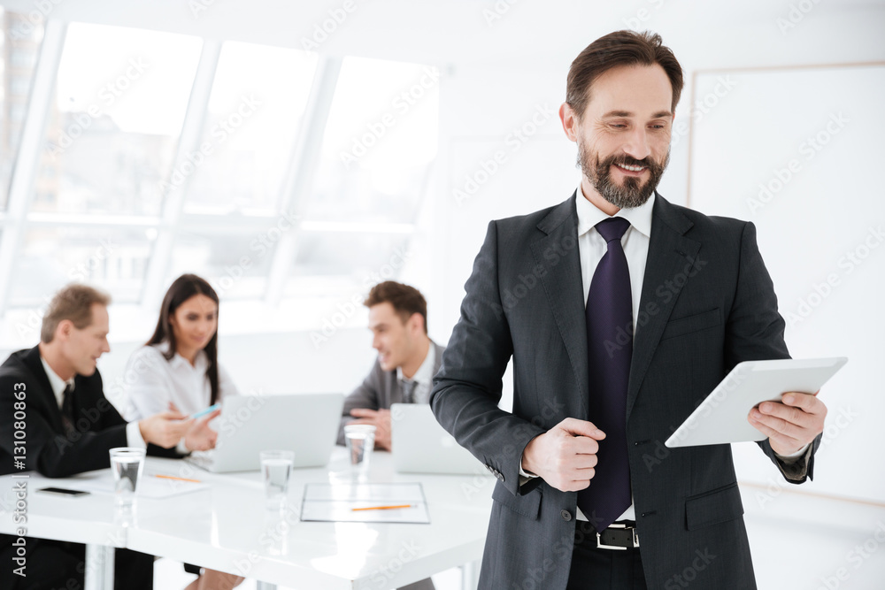 Bearded Business man with colleagues on background