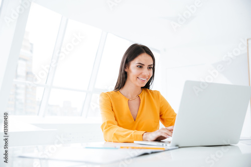 Business woman using laptop computer by the table