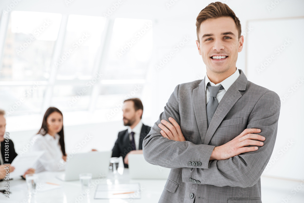 Smiling Business man with colleagues on background Smiling Business man with colleagues on background