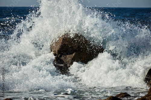 splits waves against rocks in the sea