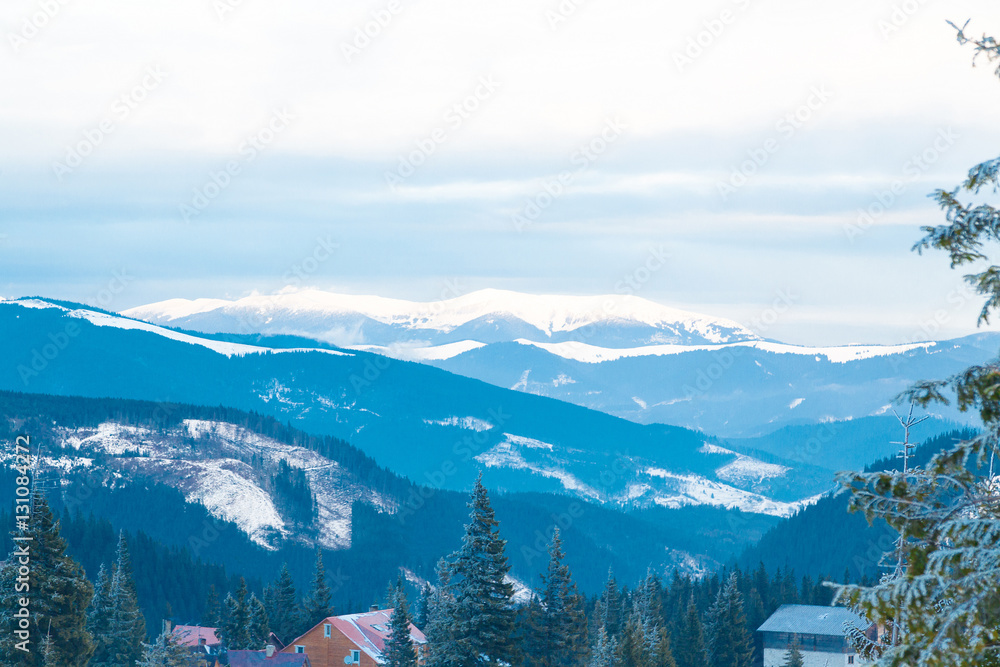 The landscape, the houses at the foot of the mountains. Snow-covered mountains and deep forests