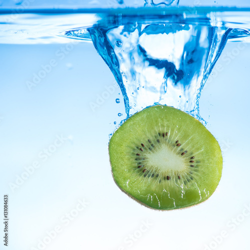 Sliced kiwi fruit splashing