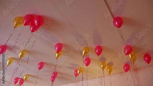 red balloons yellow hanging on ceiling of holiday