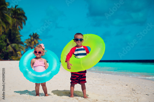 cute little boy and toddler girl play on beach