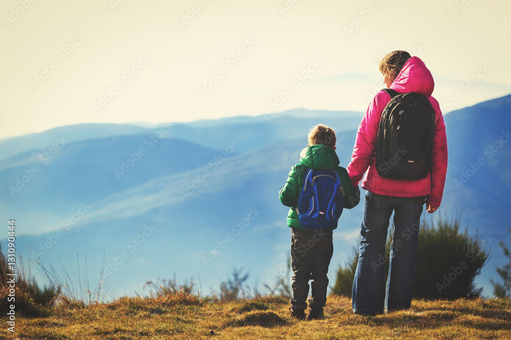 family travel concept- mother and son hiking in mountains