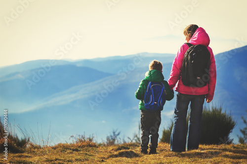 family travel concept- mother and son hiking in mountains