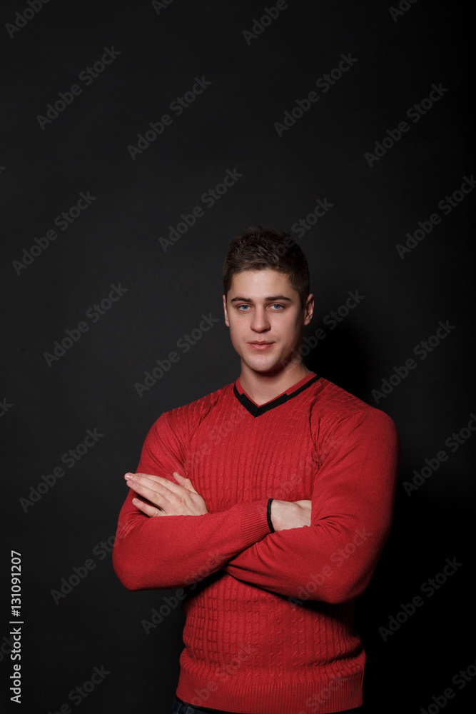 Lovely man standing on a black background. Very handsome man dressed in a red sweater. Lovely man standing on a black background. Very handsome man dressed in a red sweater.