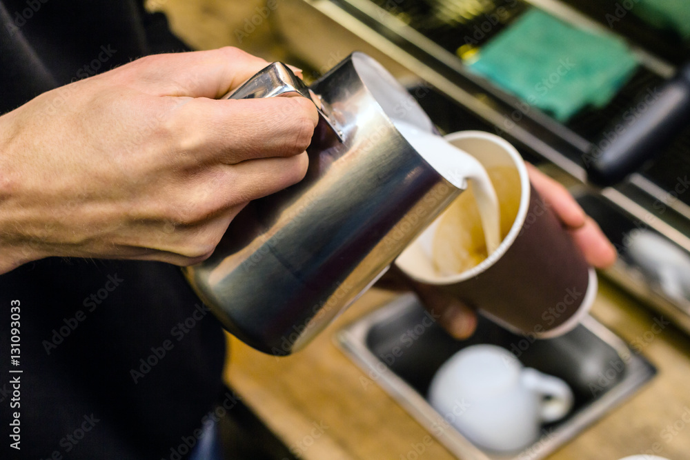Barista pouring milk to takeaway coffee. Barista pouring milk to takeaway coffee.