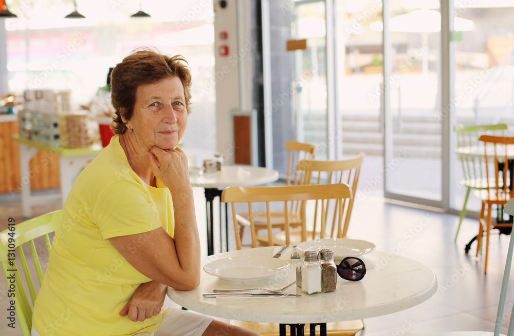 Portrait of beautiful 70 years old woman sitting in cafe