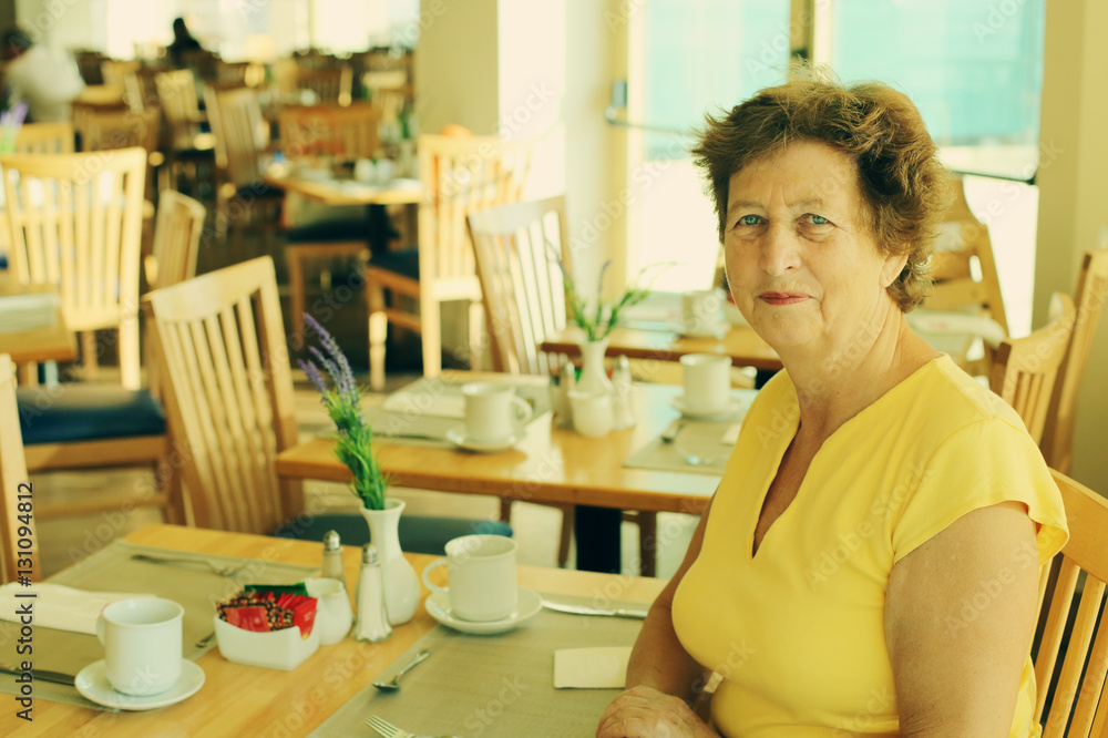 Portrait of beautiful 70 years old woman drinking morning coffee