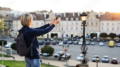 Woman tourist taking a photo of a city square photo