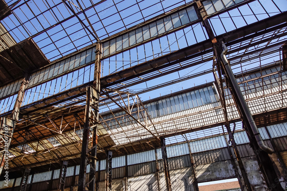 Industrial interior of an old factory building with blue sky