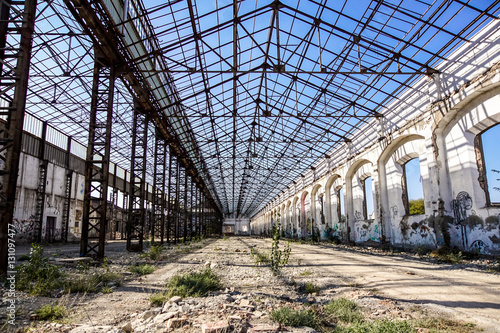Industrial interior of an old factory building with blue sky