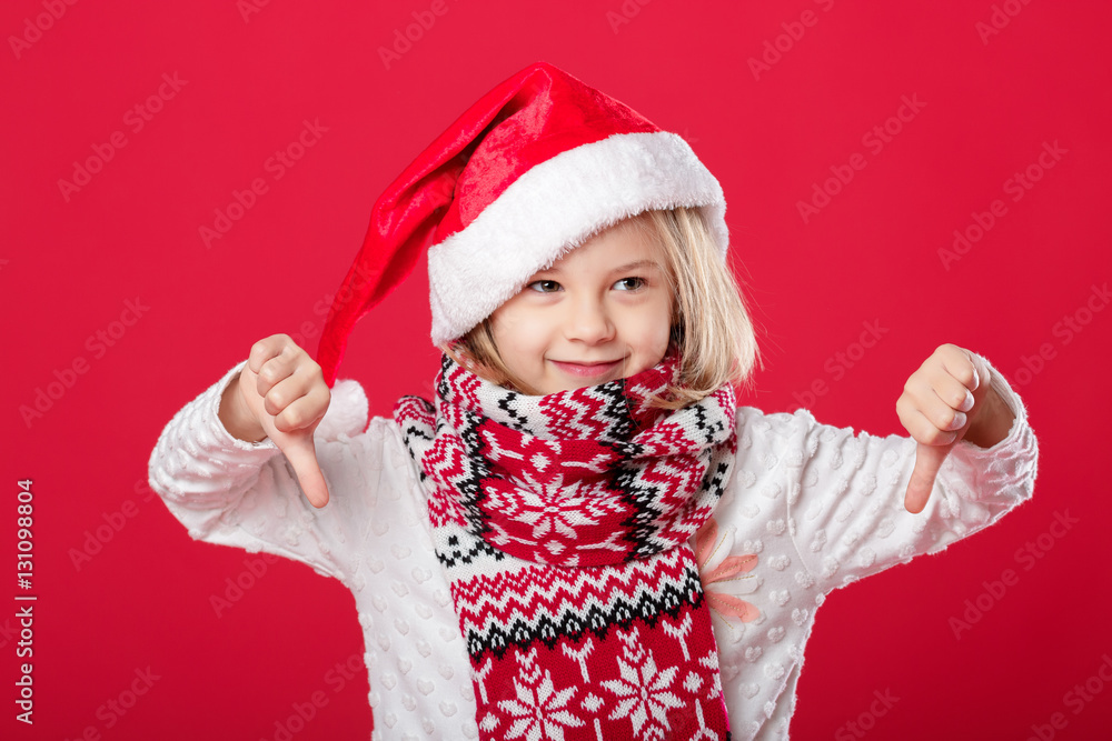 little girl in santa hat and scarf on red background little girl in santa hat and scarf on red background