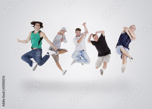 Group of young teenagers jumping over white