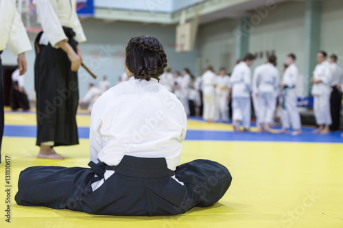 A girl in hakama shaving rest on tatami on martial arts training