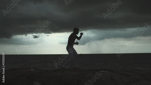 Young Man Training Martial Arts At Sunset