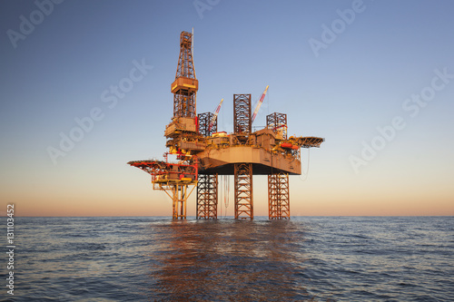 Offshore Jack Up Rig in The Middle of The Sea at Sunset Time