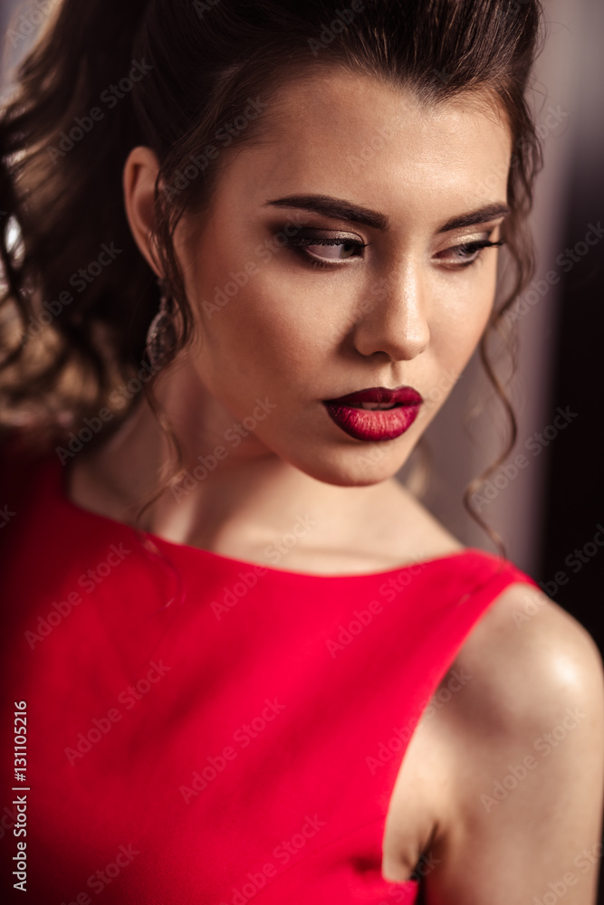 young lady in a gorgeous red evening dress in interior young lady in a gorgeous red evening dress in interior