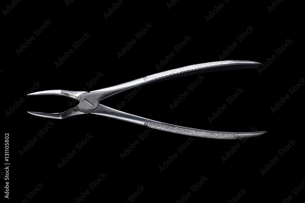 Dental pincers to remove the front teeth on black background Dental pincers to remove the front teeth on black background