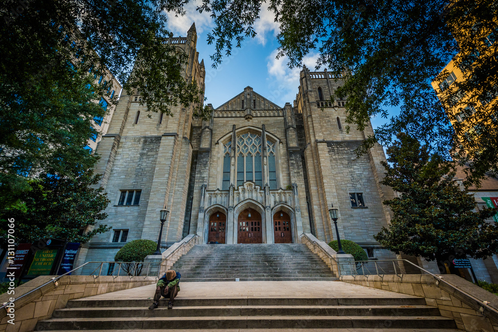 Fototapeta premium Man sitting on the steps of First United Methodist Church, in Up