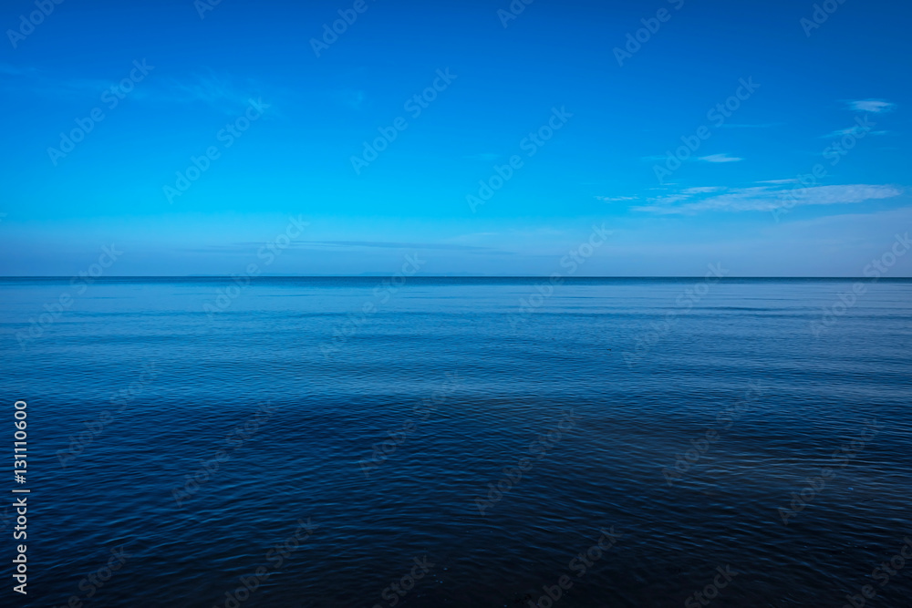 Tranquil dark and deep ocean with blue sky
