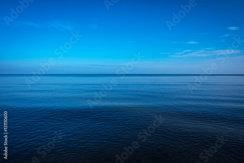 Tranquil dark and deep ocean with blue sky