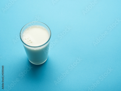 Glass of milk on the blue background.