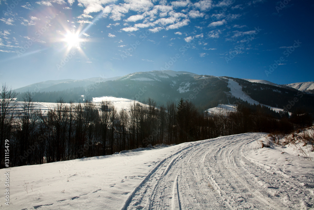 Winter snowy landscape in mountain village on blue sky Winter snowy landscape in mountain village on blue sky