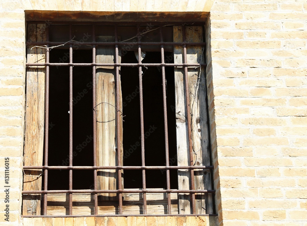 window of an abandoned house with iron bars