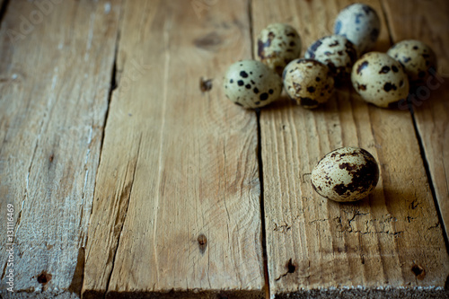 Scattered quail eggs on aged planked wood background, rustic vintage style, minimalist, kinfolk, Easter, tranquility and simplicity concept