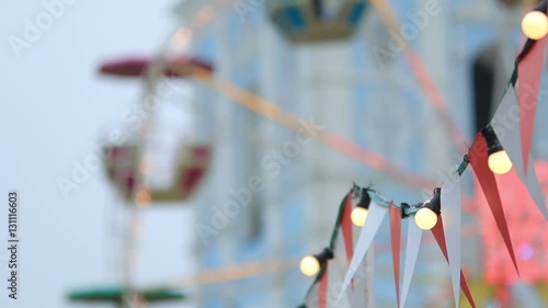 Christmas fair details with garland in front of spinning Ferris wheel (1080p, 25fps, tripod)