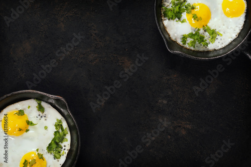 Pans with fried eggs and herbs