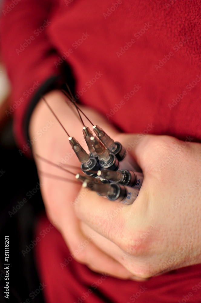 Several syringes in male hands close up