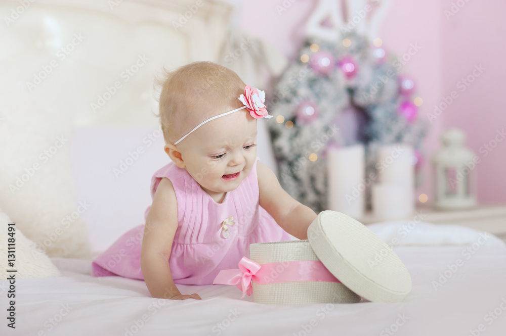 beautiful little girl opening a Christmas gift, the background  tree