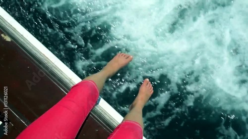 dangling feet off of cruising boat