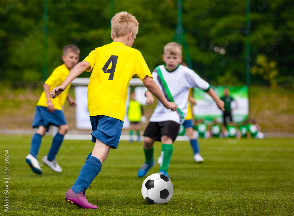 Boys Kicking Soccer Ball. Children Soccer Team. Kids Running with Ball on Football Pitch. Young Soccer Players in Action