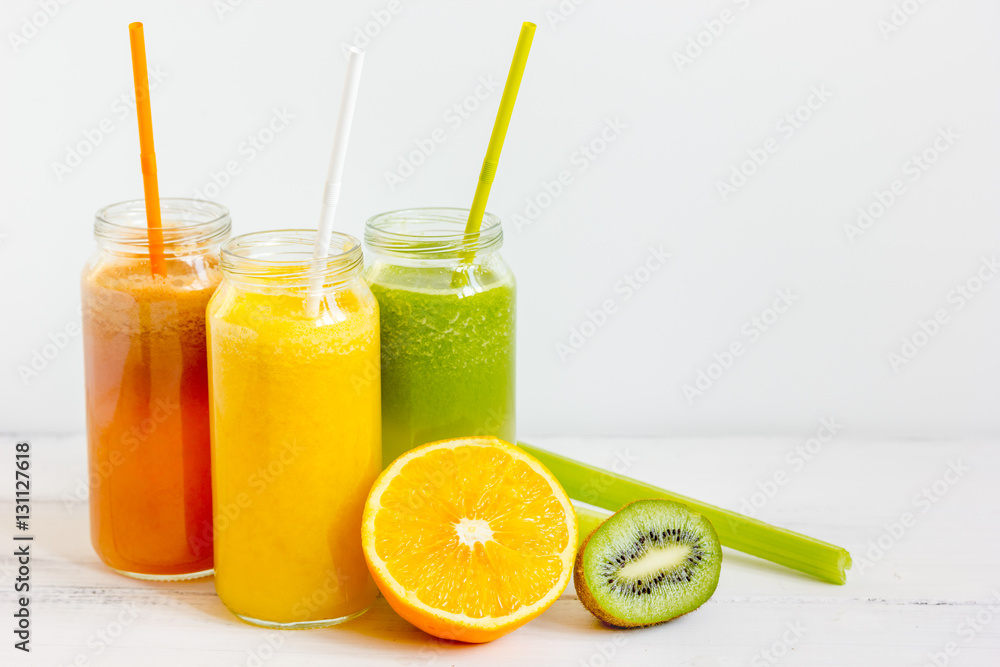 Fresh detox juices in glass bottles on white background Fresh detox juices in glass bottles on white background