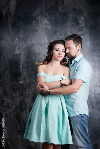 Love story. Young couple in blue dress and tshort in studio photo