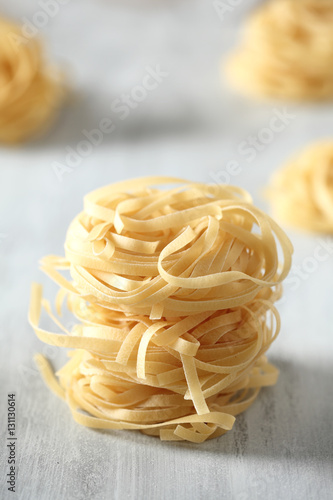 raw rolls of Italian tagliatelle noodle on a wood