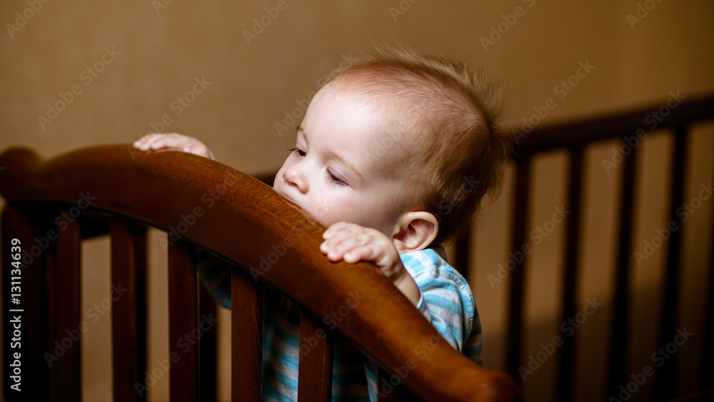 baby chewing on the crossbar of his crib Stock Photo Adobe Stock